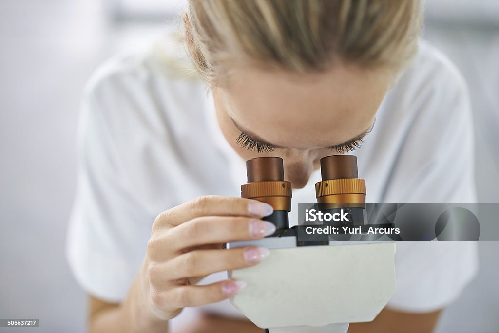 To find the answer, adjust your focus Shot of a beautiful woman in a laboratory working with a microscope Pathologist Stock Photo