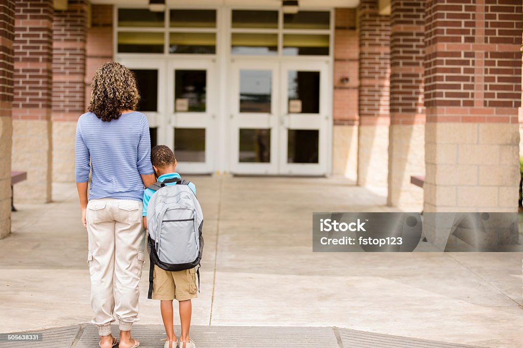 Nervous boy. First day of school.  Holds on to mom. Back to school... Cute, African descent little boy clings to his mom for reassurance on the first day of school.  Education Stock Photo