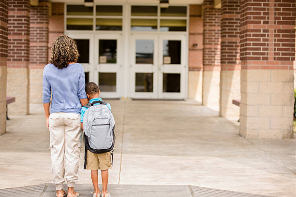 Nervous boy. First day of school.  Holds on to mom. Back to school... Cute, African descent little boy clings to his mom for reassurance on the first day of school.  anxiety stock pictures, royalty-free photos & images