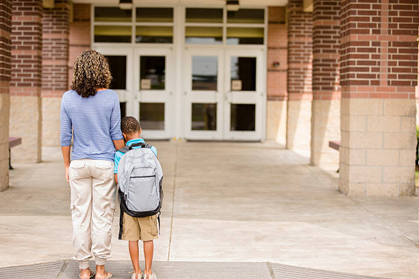 Nervous boy. First day of school. Holds on to mom. Back to school... Cute, African descent little boy clings to his mom for reassurance on the first day of school. worried mom with kids stock pictures, royalty-free photos & images