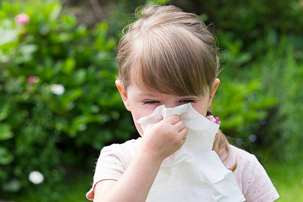 pequena menina com lenço de bolso em um jardim - tissue box flu virus kleenex imagens e fotografias de stock