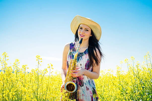 istock Woman with saxophone in rapeseed field 505638902