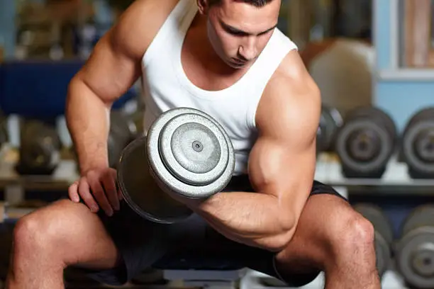 A muscular young man working out in the gym