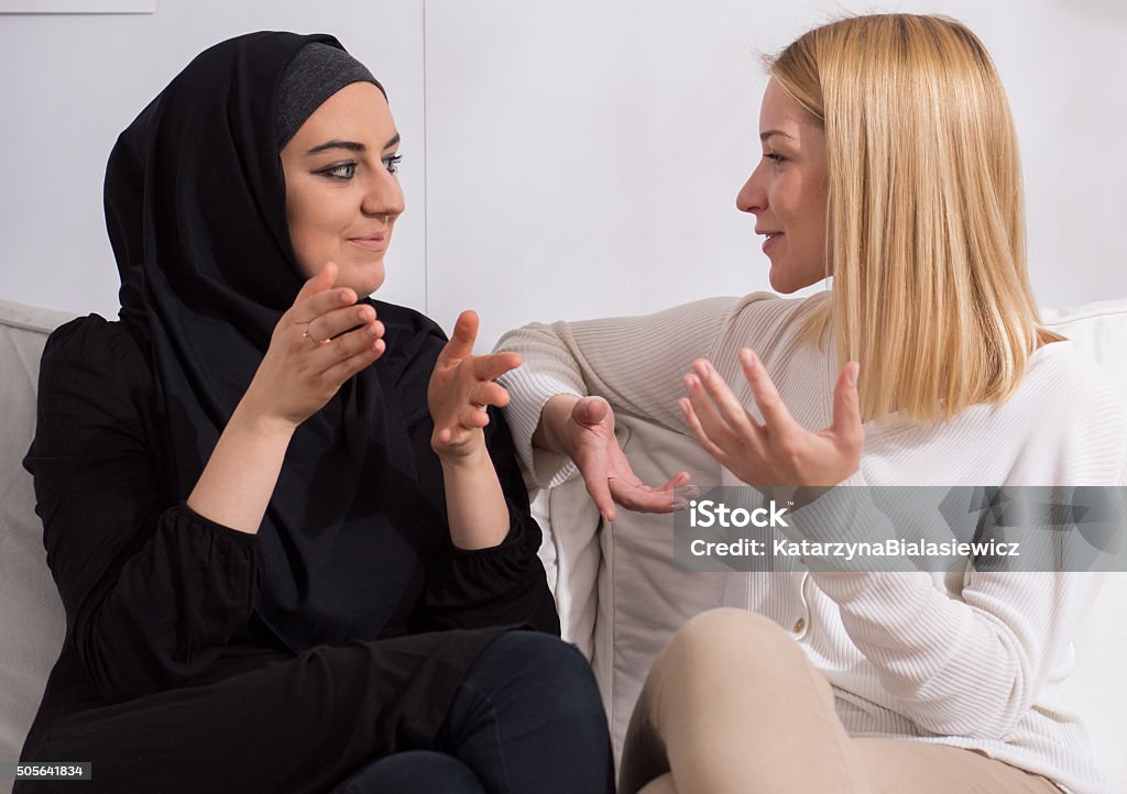 Girls of different ethnicity Two beautiful girls of different ethnicity talking Islam Stock Photo
