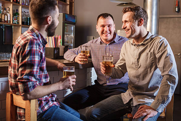 istock Happy friends drinking beer at counter in pub 505642690