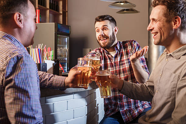 istock Happy friends drinking beer at counter in pub 505643398