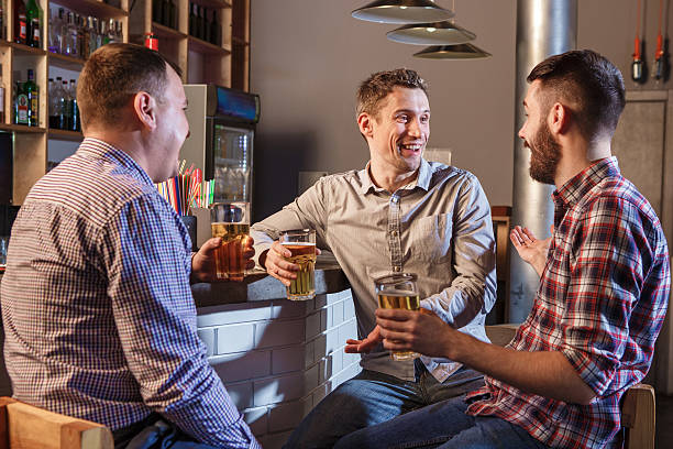 istock Happy friends drinking beer at counter in pub 505643624