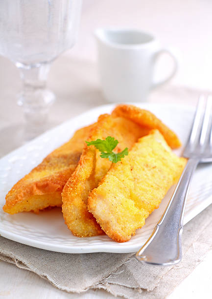 istock fish fillets fried in corn meal on a white plate 505643630