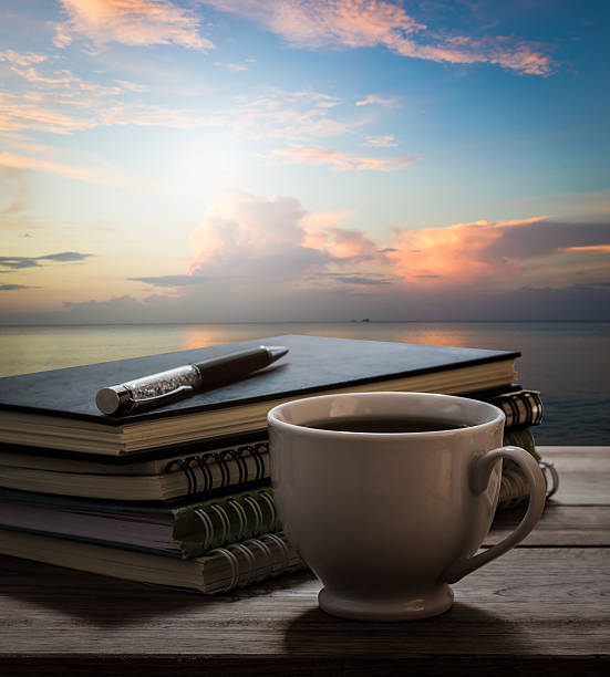 istock Coffee break with notebooks and pen on wooden table 505645480