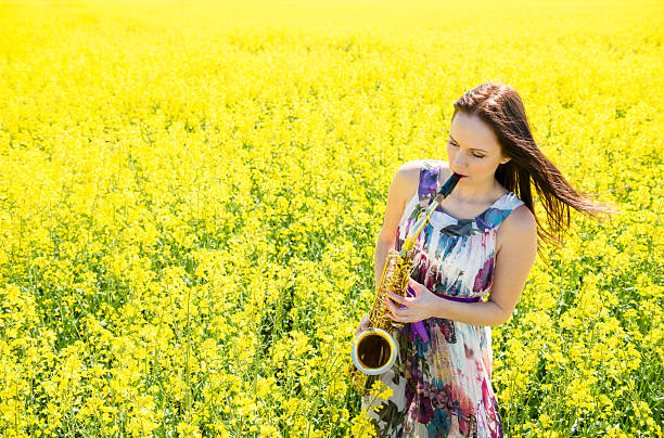 istock Woman playing saxophone in rapeseed field 505645736