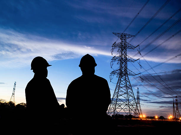 istock silhouette of engineers standing at electricity station 505645842