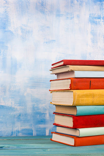 istock Stack of colorful hardback books, open book on blue background 505645876