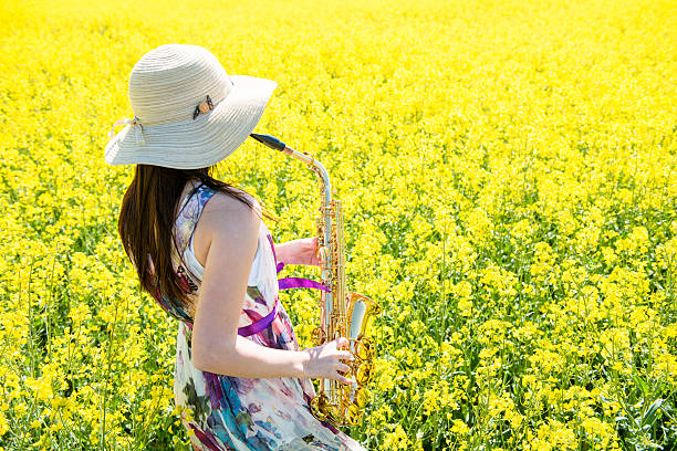istock Woman playing saxophone in rapeseed field 505647642