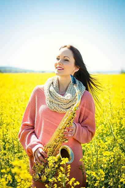 istock Woman with saxophone in rapeseed field 505649398