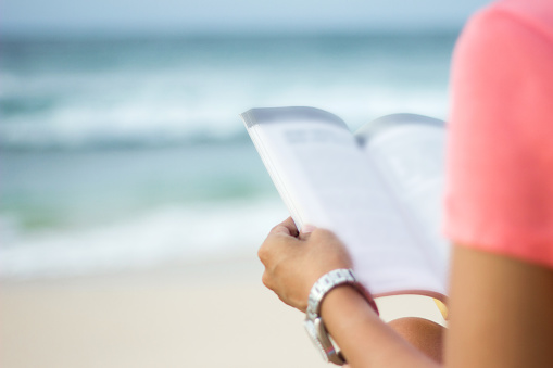Young women reading novel at the beach