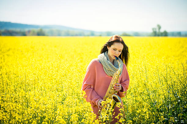 istock Woman playing saxophone in rapeseed field 505650876