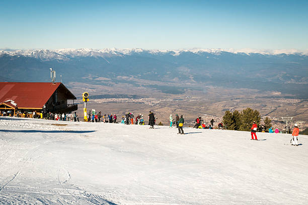 Bansko, Bulgaria - December 29, 2015: Skiers skiing on a slope in the resort next to the  upper station