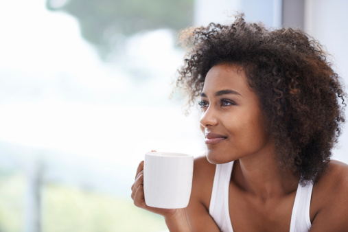 Cropped shot of a young woman enjoying a cup of coffee