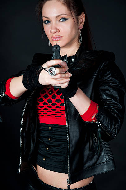 istock Danger girl holding a gun on black background 505655761