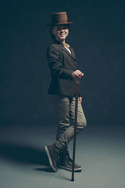 istock Smiling boy wearing jacket and hat standing with cane. 505662480