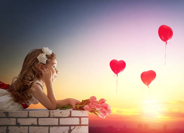 istock girl looking at red balloons 505664954