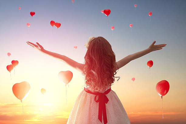 istock girl looking at red balloons 505665068