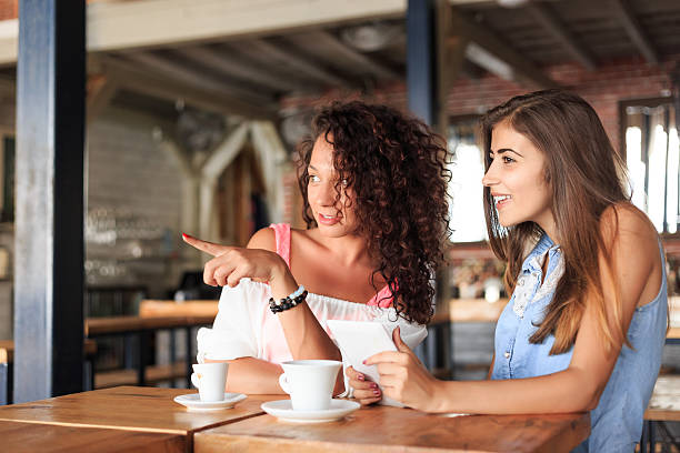 istock Girls drink coffee at bar looking through window 505666164