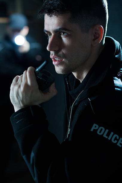 istock Police officer holding radio 505672646