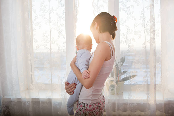 istock Loving mother playing with her baby on window 505674452
