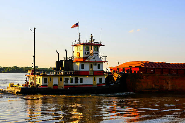 istock Mississippi river ditch boat pushing a loaded barge down stream 505683604