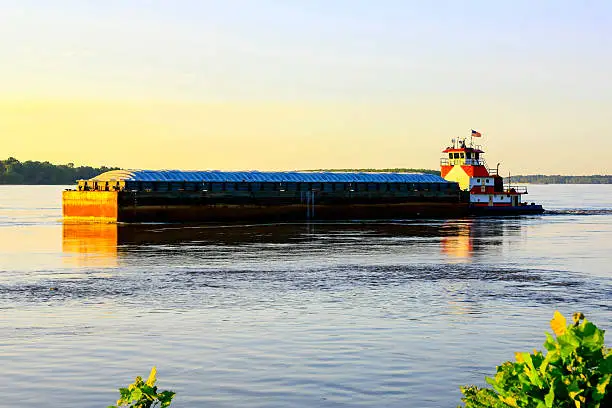Photo of Mississippi river ditch boat pushing a loaded barge down stream