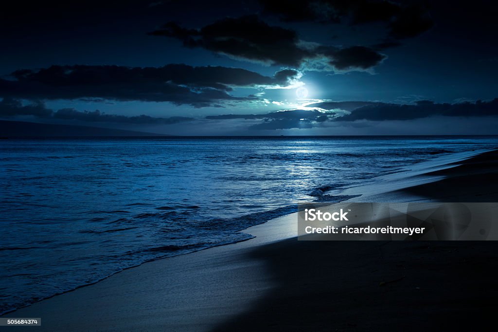 Quiet Moonlit Beach in Maui Hawaii This photo illustration depicts a quiet and romantic moonlit beach in Maui Hawaii. Night Stock Photo