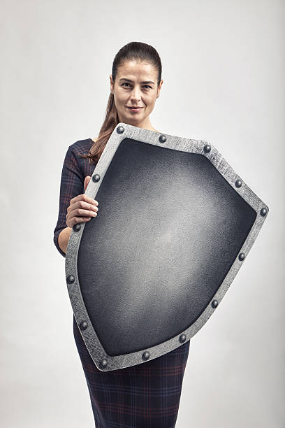 Woman protecting herself with a shield Woman protecting herself with a shield weapon photos stock pictures, royalty-free photos & images
