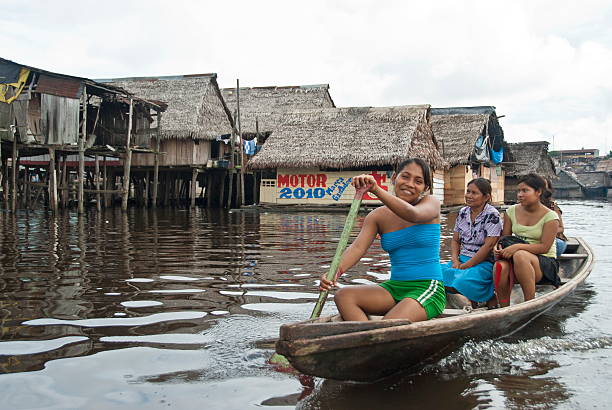 Peruvian family floats on water street in Belen, Iquitos, Peru. stock photo
