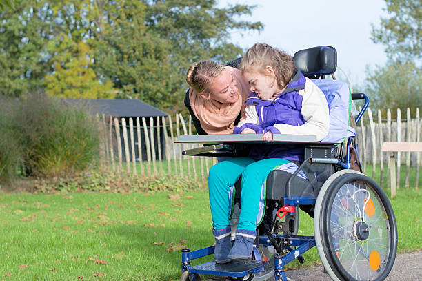 istock Disability a Disabled child in a wheelchair relaxing outsidee 505689628