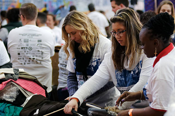 Volunteers Sort Business Attire for MLK Day of Service Philadelphia, PA, USA - January 18, 2016; Community members, joined by elected officials, volunteer at a gently used business attire sorting project during the 21st Martin Luther King Day of Service in Philadelphia, PA. martin luther king jr day stock pictures, royalty-free photos & images