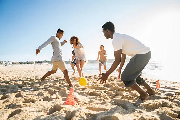 Photo of People playing soccer at the beach