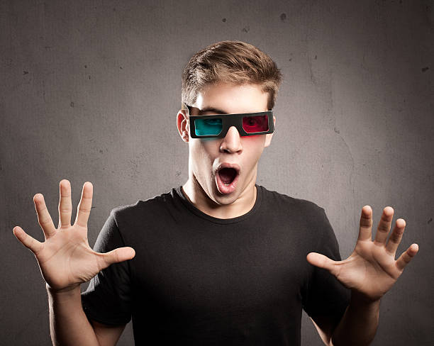 young man watching a movie wearing 3d glasses