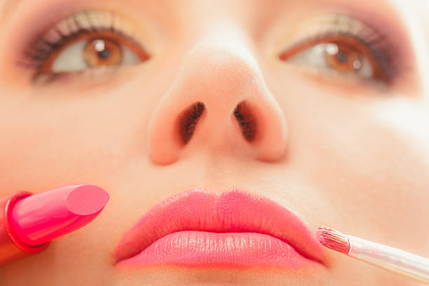 istock Woman applying lipstick with brush on lips. Makeup 505693686