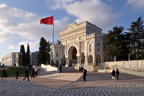Istanbul, Turkey - December 19, 2015: People rest and socialize in Beyazit Square, on the background the main gate of the historical Istanbul University located in Istanbul, Turkey.