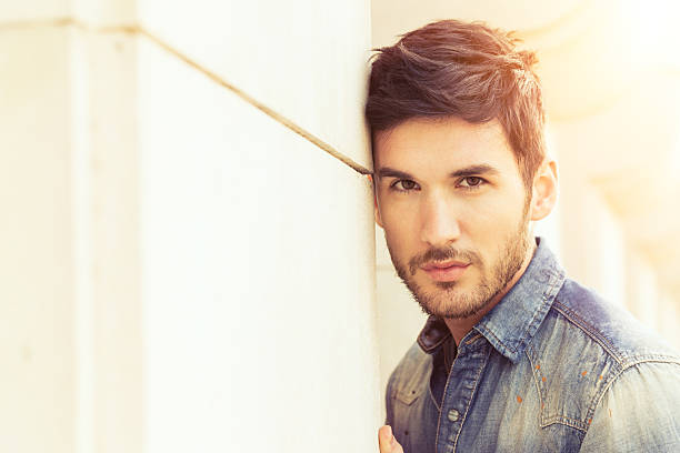 istock Fashionable young man standing by the wall 505700231