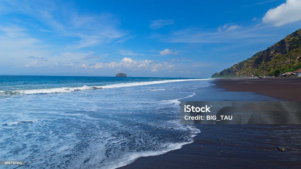 The beach with black volcanic sand The beach with black volcanic sand on the island of Bali in Indonesia on a sunny summer day. Above Stock Photo