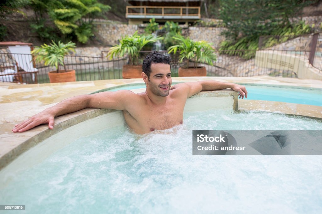 Two Guys Sitting In A Hot Tub Man Relaxing In The Hot Tub Stock Photo - Download Image Now - Hot Tub