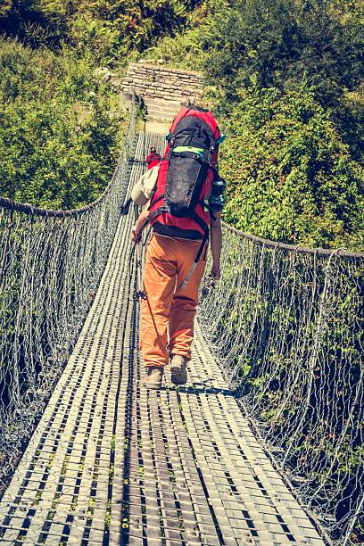 istock Female hiker crossing a suspension bridge. 505714610