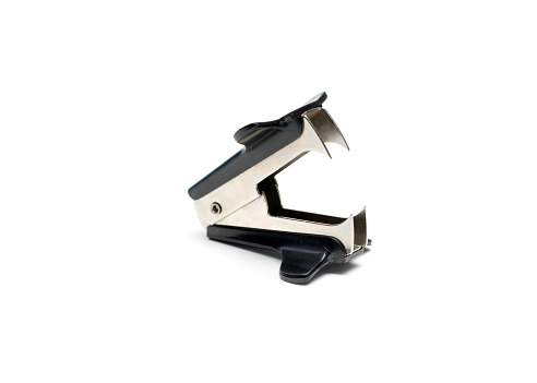 Closeup of a staple remover on a white background with shadows.  