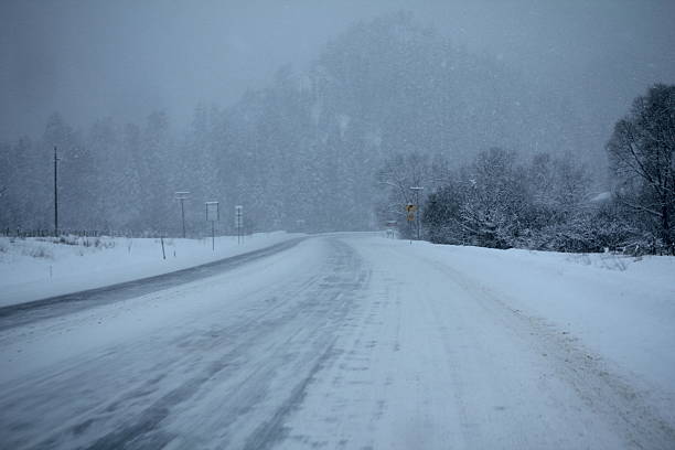 schneien auf schnee aufwarten road - aufwarten stock-fotos und bilder