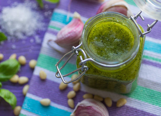 istock Green pesto in a glass jar and ingredients 505721929
