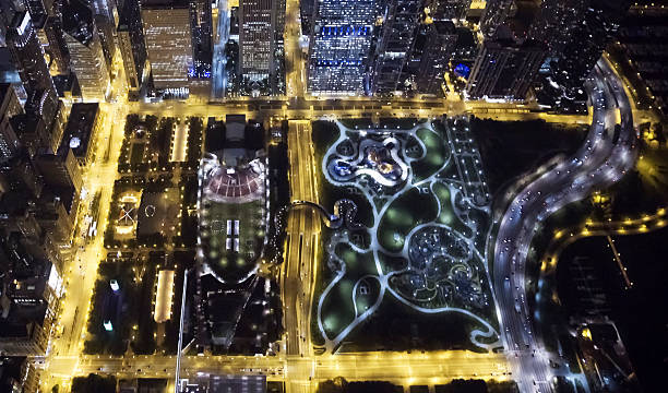 Looking Down on Chicago's Millennium Park and Maggie Daley Park Aerial view from a helicopter looking down on Millennium Park and Maggie Daley Park in Chicago at night. millennium park chicago stock pictures, royalty-free photos & images