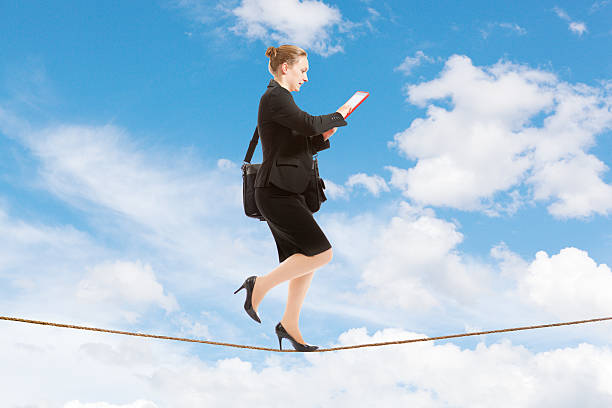 istock Businesswoman Using Digital Tablet Computer Balancing on Tightrope 505726393