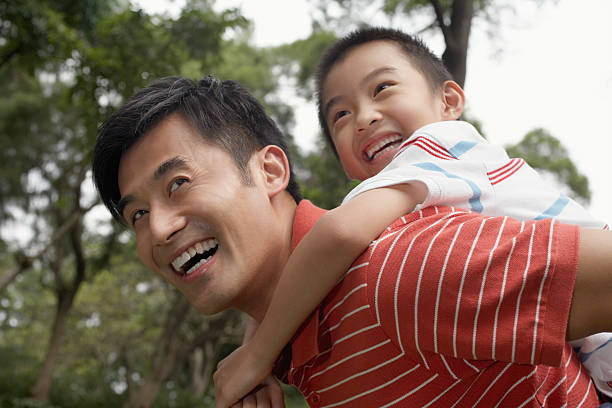 istock Father And Son Enjoying Piggyback Ride In Park 505726463